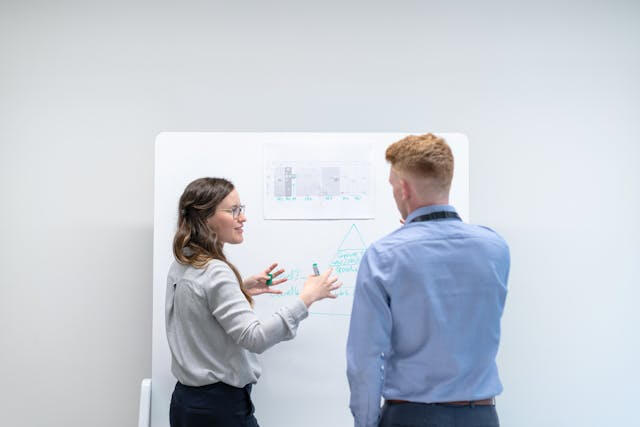 Collaborative freelance web design team in Minneapolis Two people discussing strategy at a whiteboard, representing web design teamwork in Minneapolis